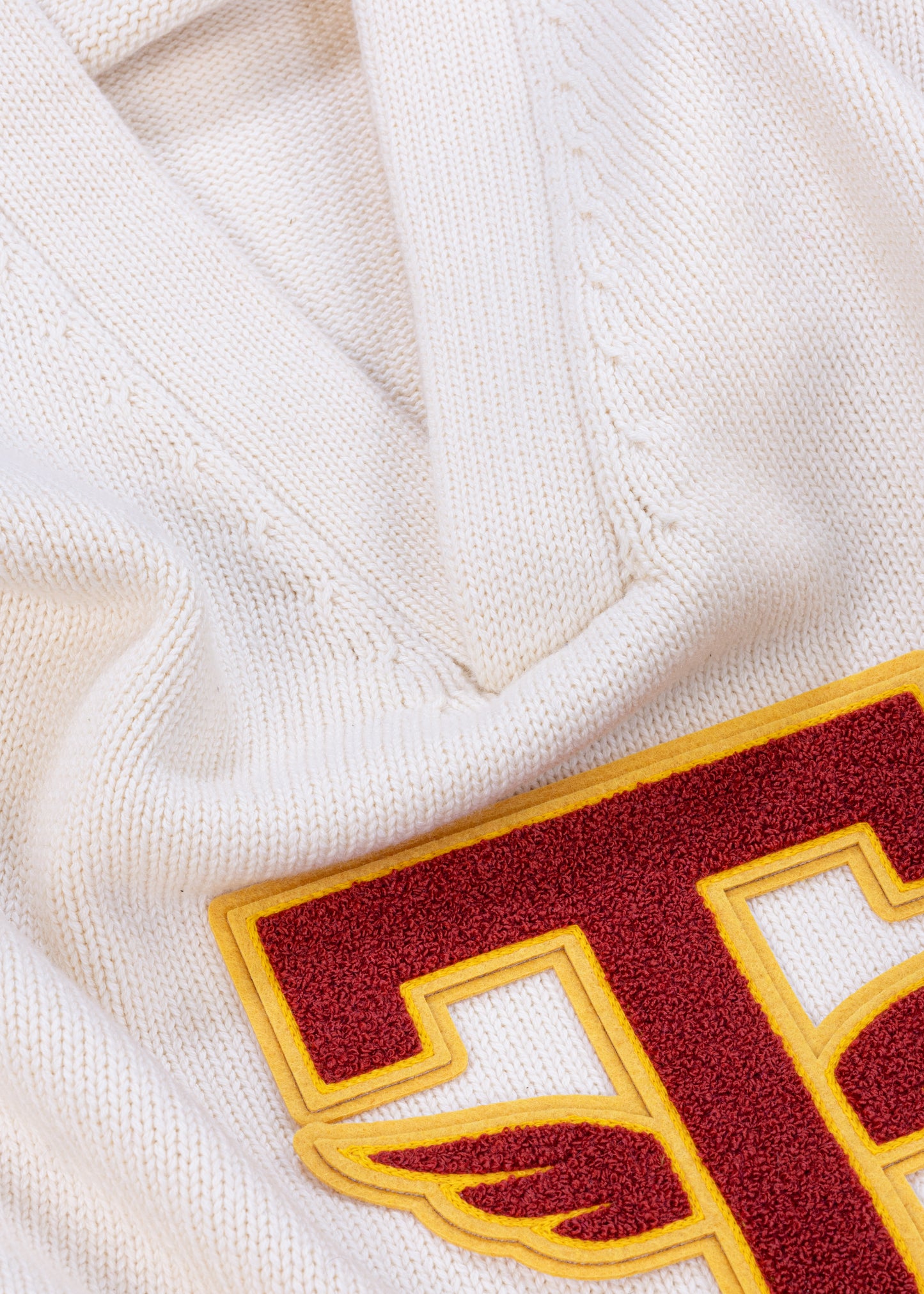 Close up detail shot of Tuskegee University v-neck pullover sweater, vintage inspired by Tuskegee University student yearbooks, wool-cotton blend, HBCU apparel. Featuring Chenille T patch