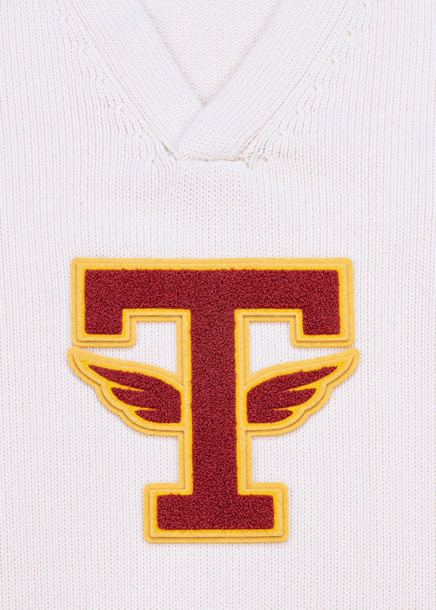 Close up detail shot of Tuskegee University v-neck pullover sweater, vintage inspired by Tuskegee University student yearbooks, wool-cotton blend, HBCU apparel. Featuring Chenille T patch