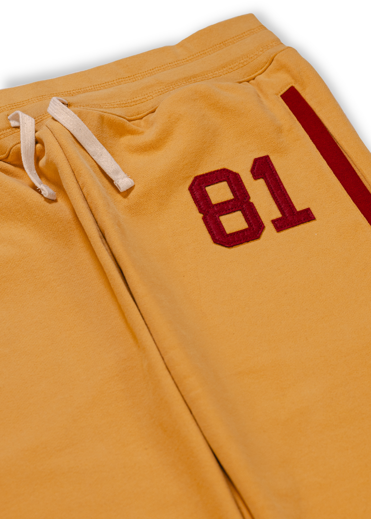 Close up of Tuskegee University Sweatpants , old gold with felt appliqué Tuskegee founding year detail.