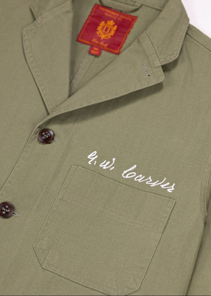 Closeup shot of Olive Chore coat featuring the signature of George Washington Carver