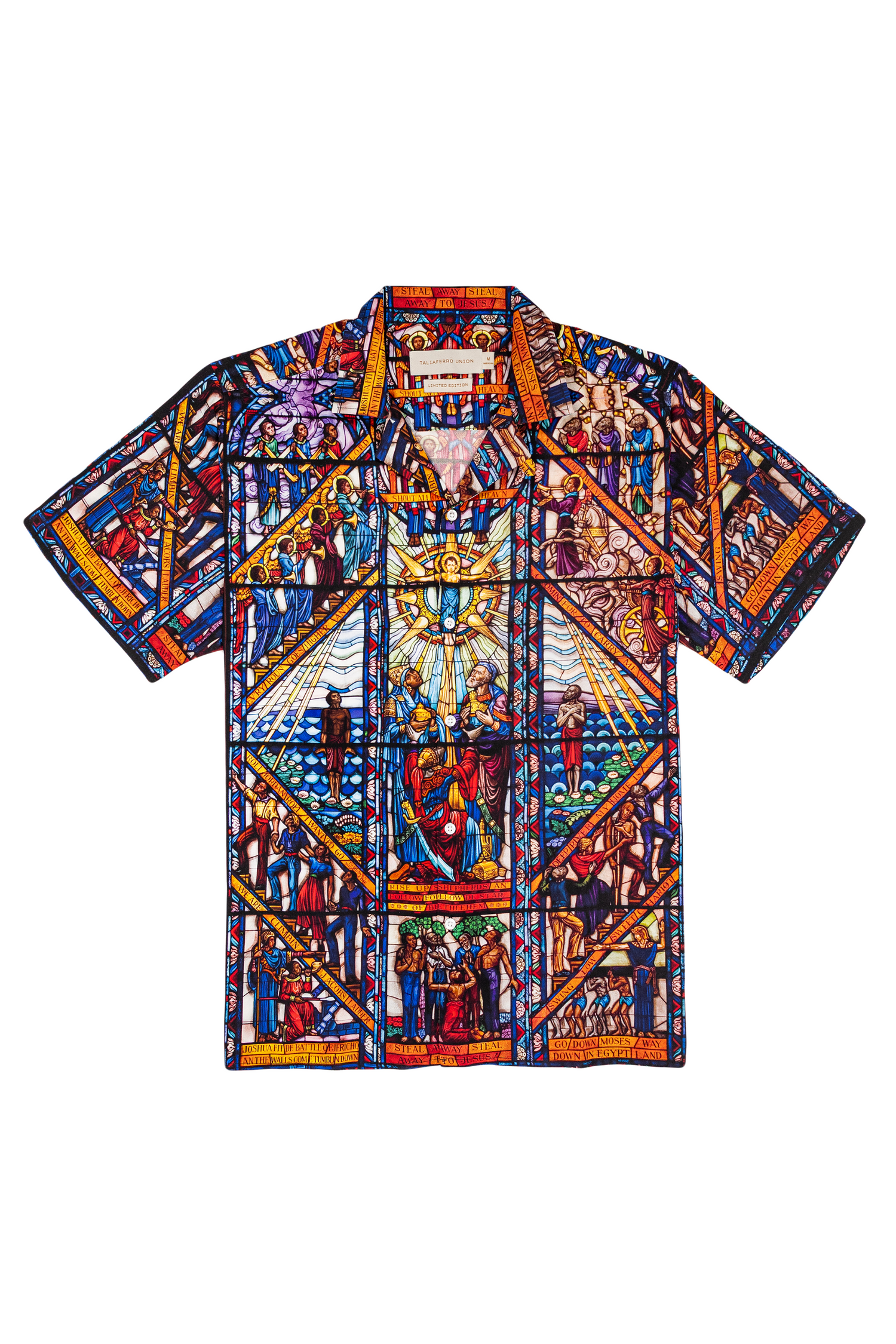 camp collar viscose shirt with a pattern inspired by the Tuskegee University Chapel's "singing windows" stained glass installation, standing in a room with light-colored walls.