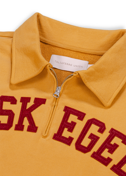 Close up detail shot of old gold Tuskegee University sweatshirt featuring bold "TUSKEGEE" felt appliqué lettering across chest. Vintage HBCU apparel 